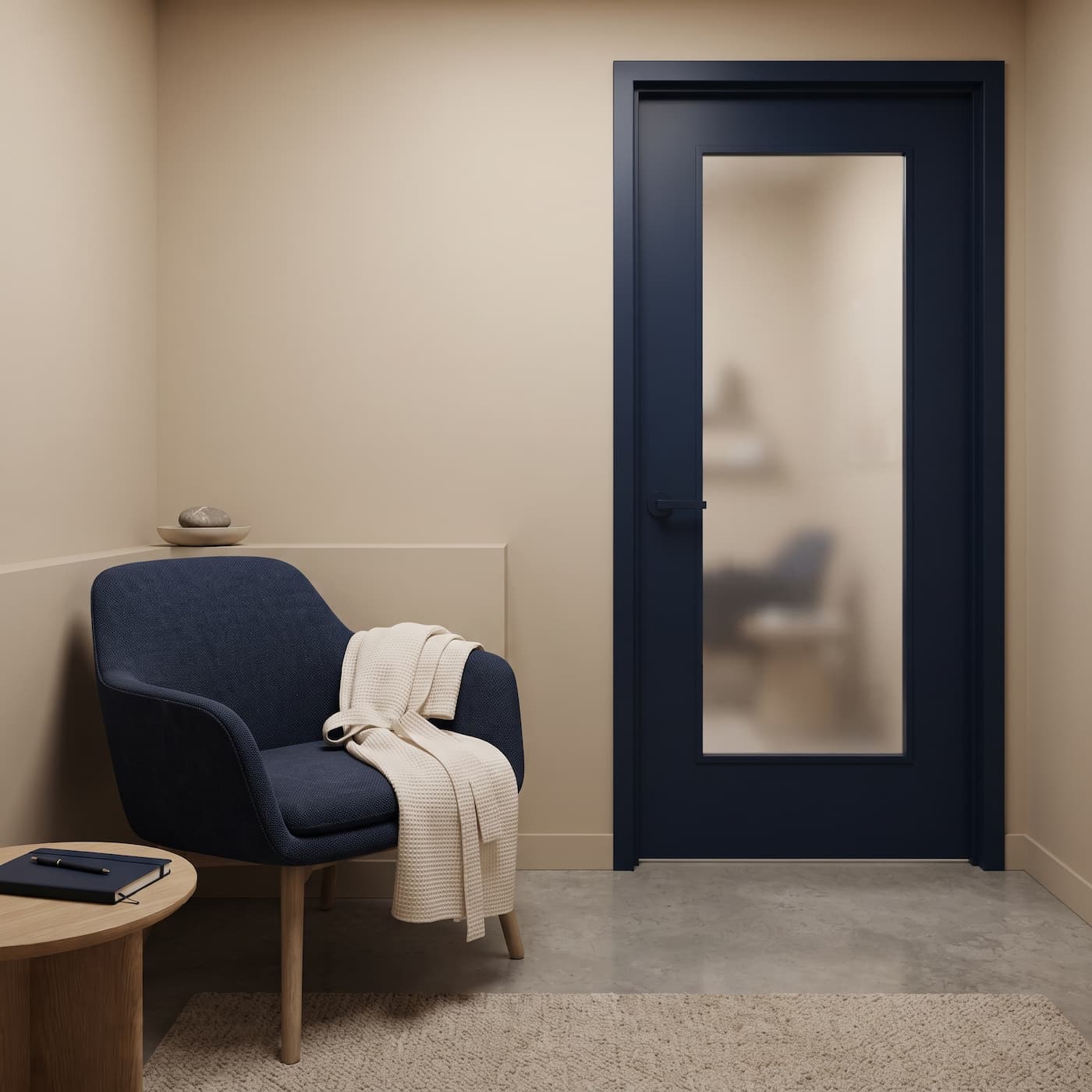 A private waiting corner with an armchair beside a frosted consulting-room door